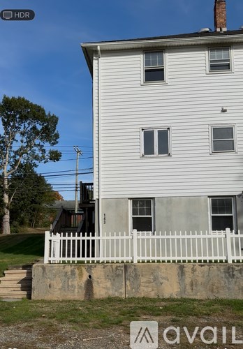A white house with a fence in front of it.