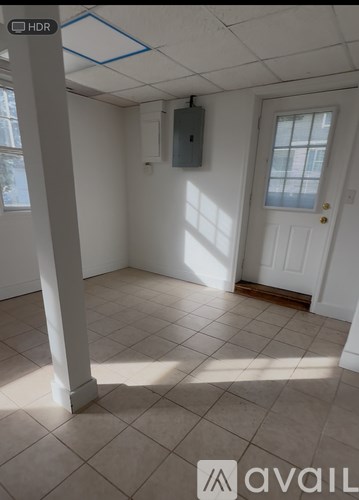 A room with white walls and a white door with a window above it.