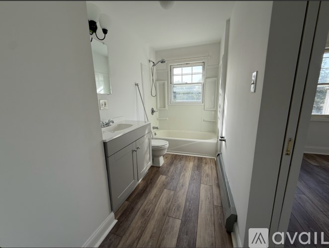 A bathroom with a window and a wooden floor.