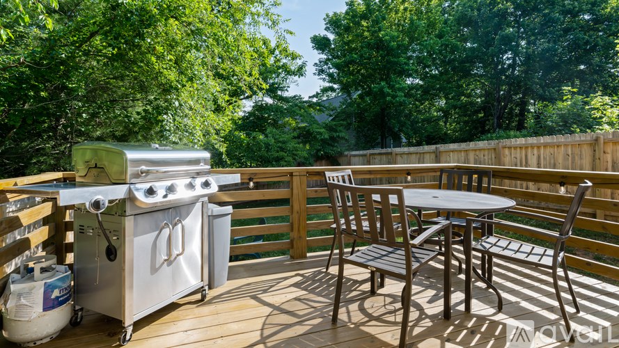 A small outdoor kitchen with a grill and a table.
