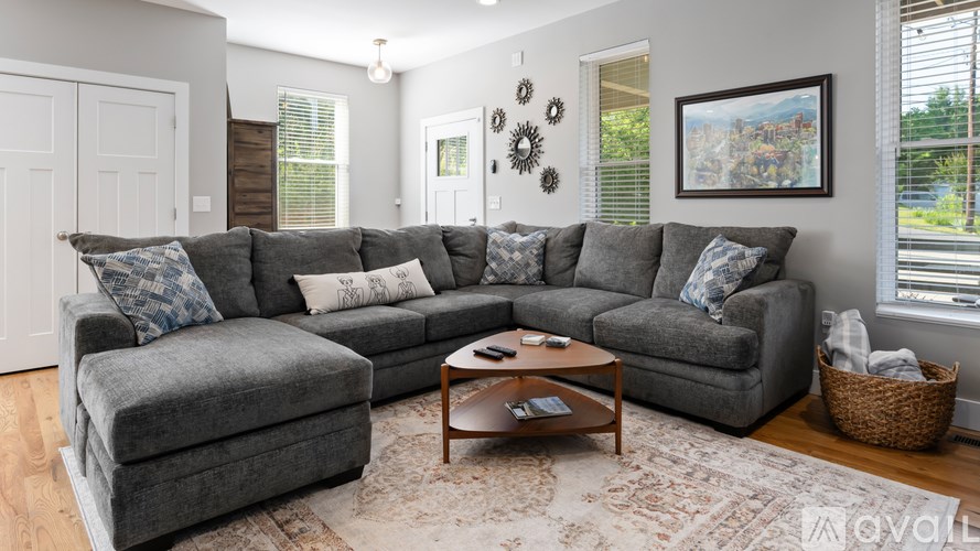 A living room with a grey couch and a coffee table.