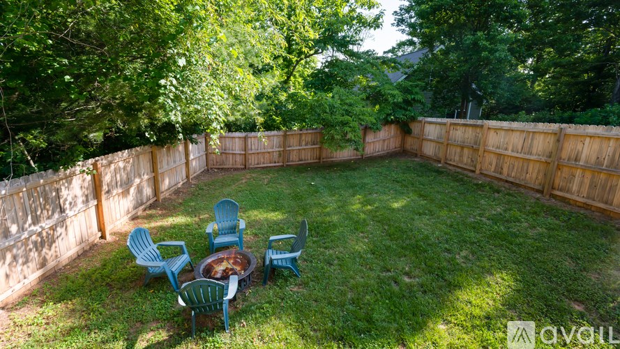 A backyard with a fire pit and chairs.