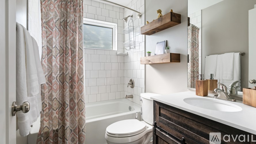 A bathroom with a white sink, toilet, and a shower with a glass door.