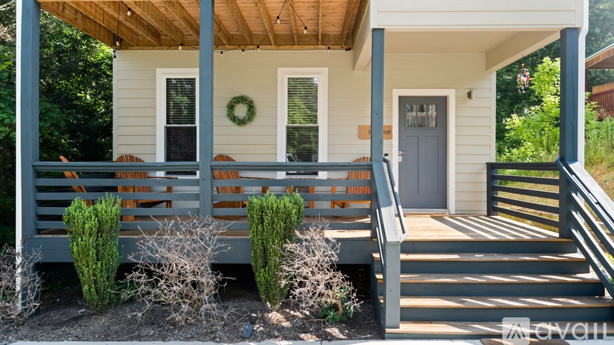 A small house with a front porch and a wreath on the door.