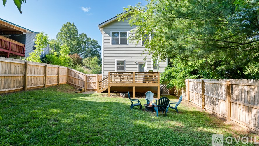 A house with a deck and chairs in the backyard.