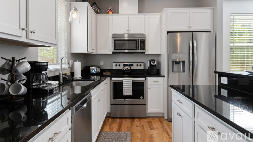 A kitchen with black countertops and white cabinets.