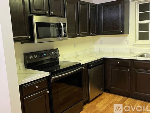 A kitchen with black cabinets and stainless steel appliances.