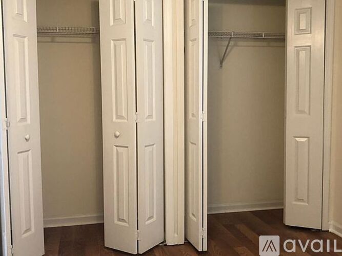 A room with three white closet doors.