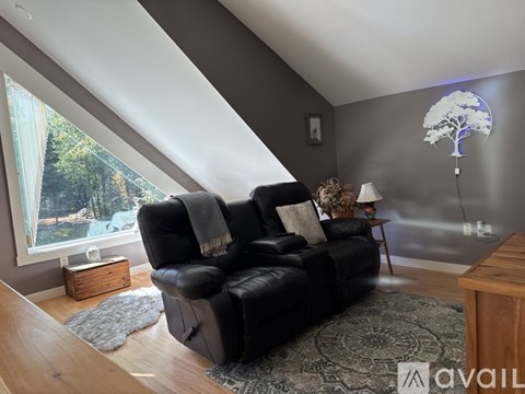 A living room with a black leather sofa and a tree-shaped lamp.