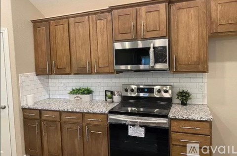 A kitchen with wooden cabinets and a granite countertop.