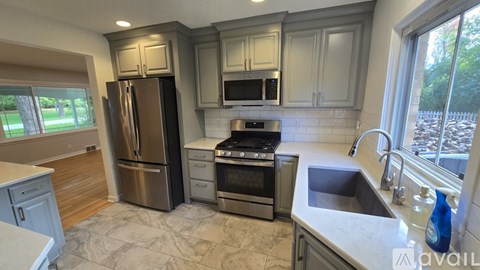 A kitchen with a sink, stove, and refrigerator.