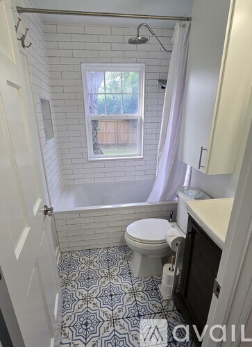 A bathroom with a toilet, sink, and shower.