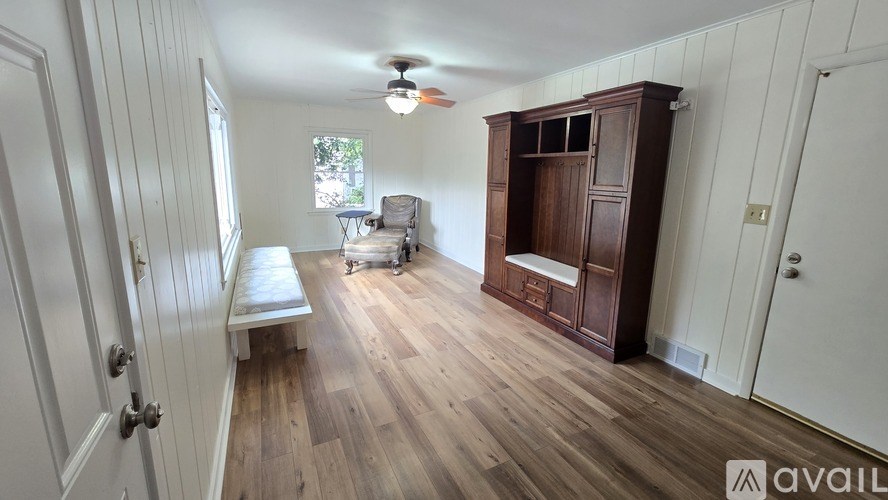 A room with wooden floors and a white ceiling fan.