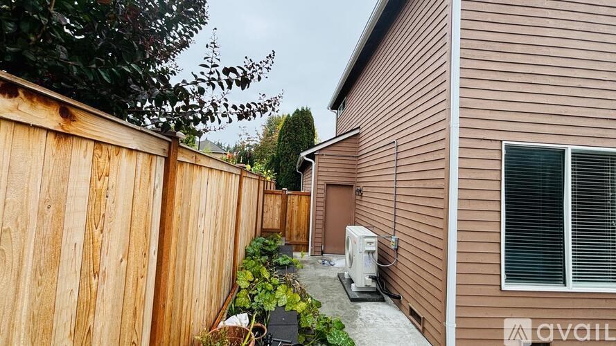 A wooden fence with green plants in front of a house.