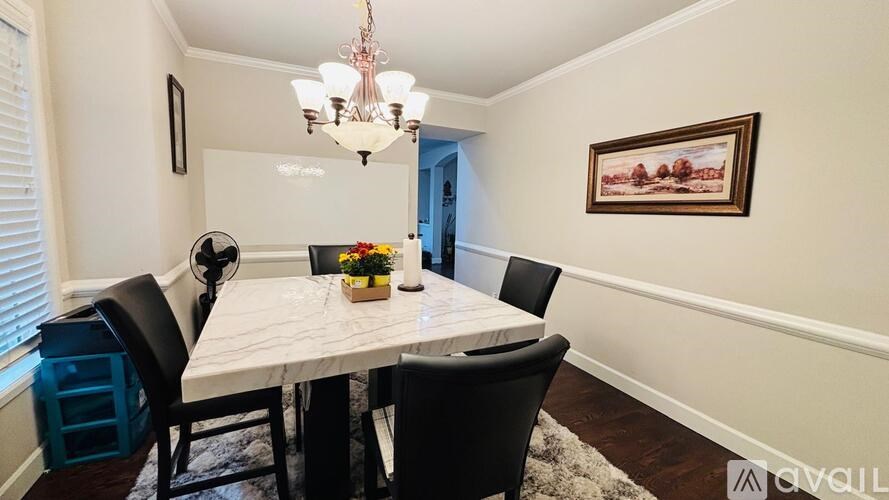 A dining room with a white table and chairs.