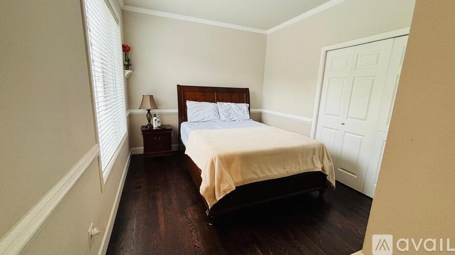 A bedroom with a bed, nightstand, and lamp.