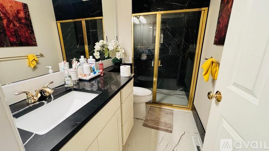 A bathroom with a sink, mirror, and shower.