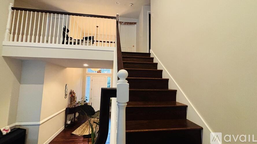 A staircase with a white railing leads to a second floor.