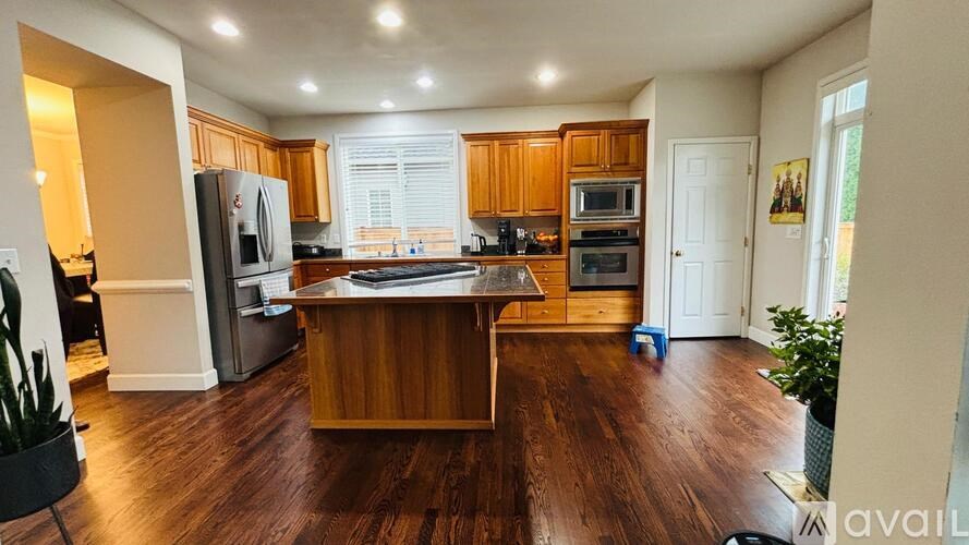 A kitchen with wooden cabinets and a wooden island in the middle.