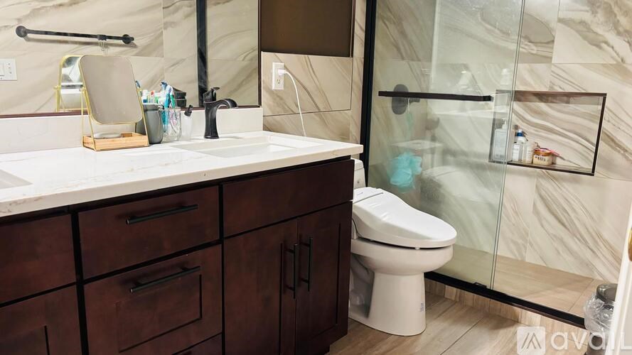 A bathroom with a white toilet and a marble counter top.