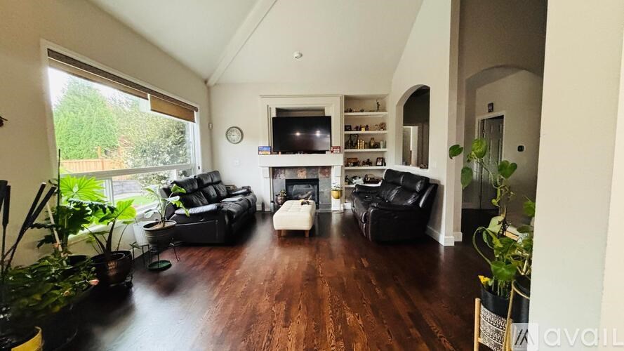 A living room with a black couch and a television.