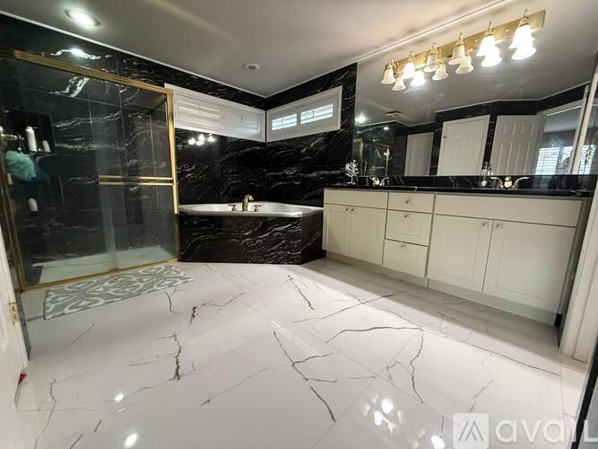A bathroom with a marble floor and black and white decor.