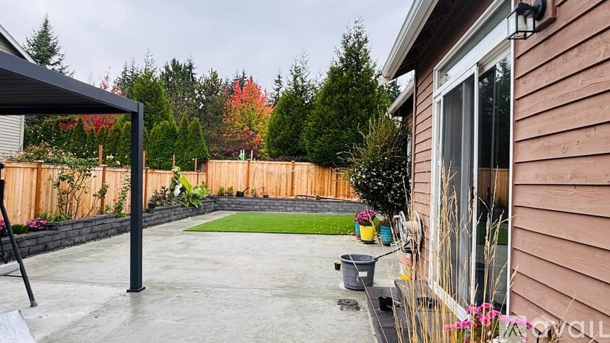 A backyard with a patio and a deck.
