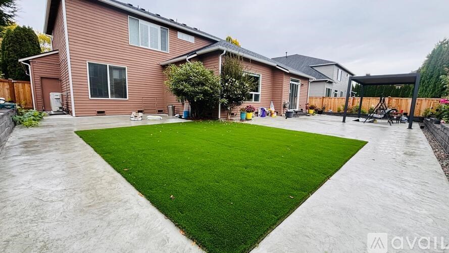 A house with a red exterior and a green lawn in front.