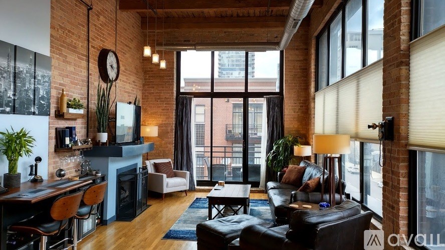 A living room with a brick wall and a fireplace.
