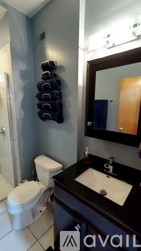 A bathroom with a toilet, sink, and mirror.