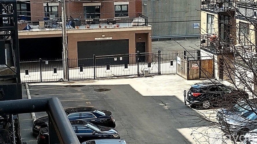 A parking lot with cars and a building in the background.