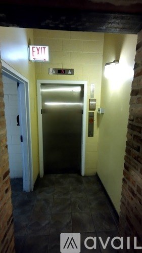 A hallway with a door and an exit sign.