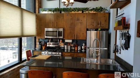 A kitchen with wooden cabinets and a stainless steel refrigerator.
