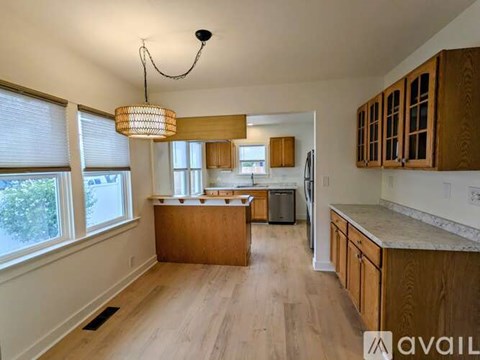 A kitchen with wooden cabinets and a large island.