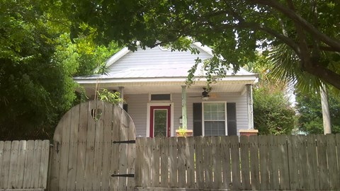 A house with a grey roof and a wooden fence.