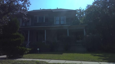 A house with a white fence and a mailbox in front.