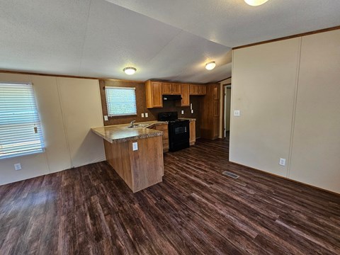 A kitchen area with wooden flooring and a countertop.