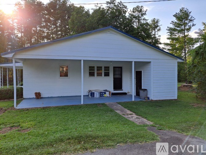 A white house with a porch and a covered patio.