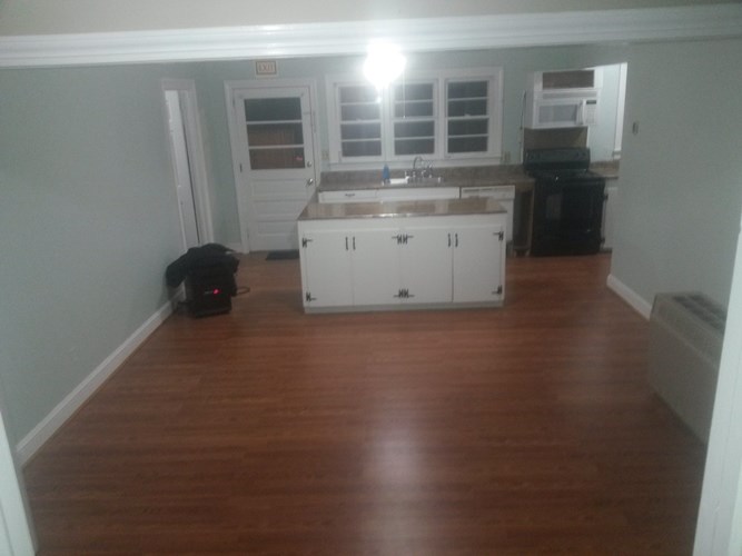 A kitchen with white cabinets and a black stove.