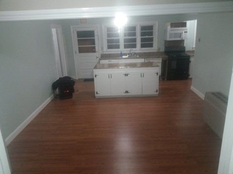 A kitchen with white cabinets and a black stove.