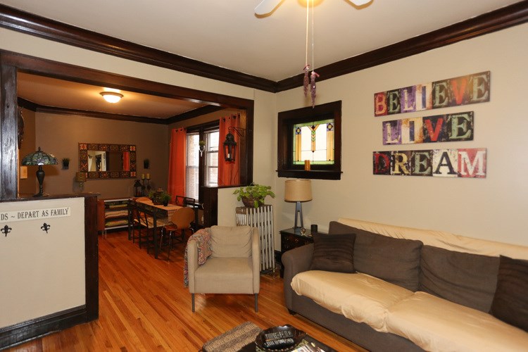 A living room with a couch, chairs, and a TV.