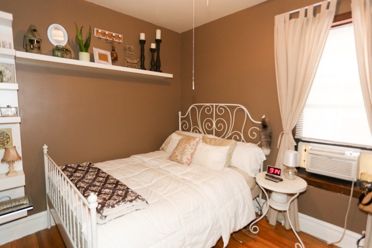 A bedroom with a white bed and a brown headboard.