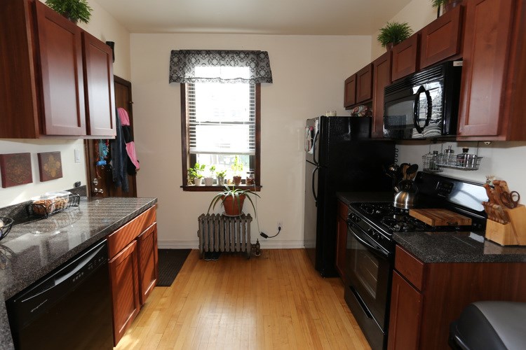 A kitchen with black appliances and wooden cabinets.