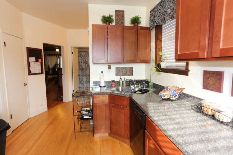 A kitchen with wooden cabinets and a granite countertop.