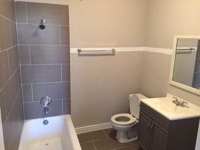 A bathroom with a toilet, sink, and bathtub.