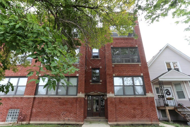 A red brick building with a black door and windows.