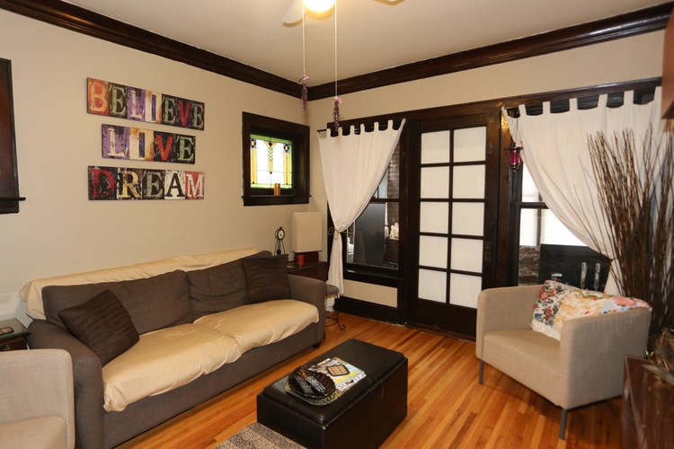A living room with a couch, chair, and a sign that says "Believe, Live, Dream.".
