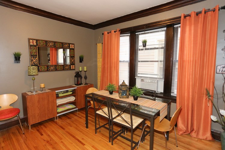 A room with a wooden floor and a table with chairs.