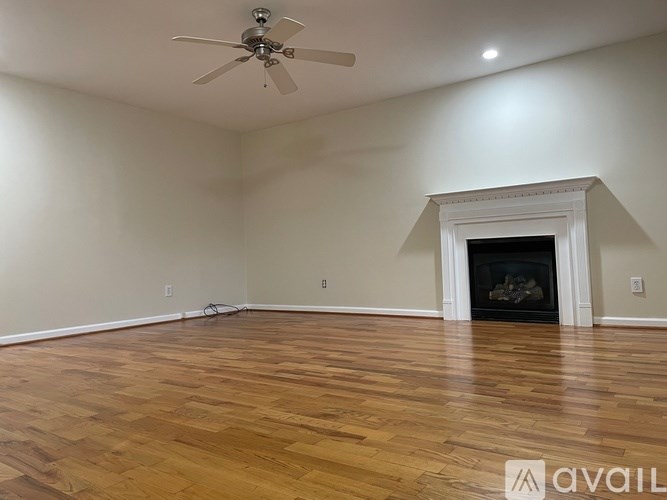 A room with a fireplace and a ceiling fan.