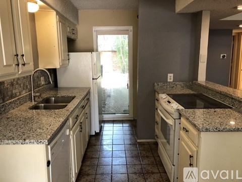 A kitchen with granite countertops and white appliances.